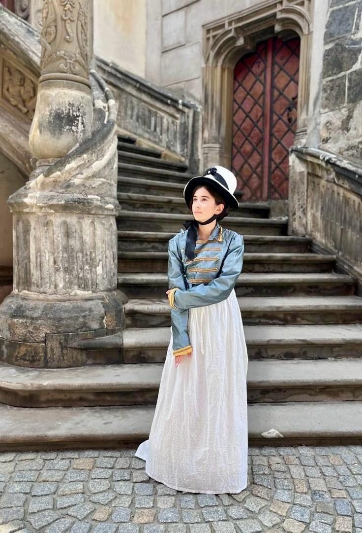 Darstellerin in Empire-Kostüm auf einer Freitreppe